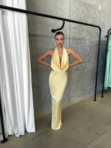 Alice Dress by Lexi, in butter yellow colour, deep cowl neckline, luxe satin fabric, halter tie-up back with adjustable strap, sleek straight fit with back split. Hire for weddings, special events, formal events, school balls.