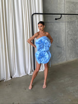 Stunning baby blue mini dress featuring two large 3D flowers at the front, with an adjustable lace-up back for a custom fit. Crafted from soft-sheen fabric for a luxurious, polished look, the dress is fully lined for comfort. Perfect for cocktail parties, special occasions, or nights out, with bold floral details and a sophisticated design, hire from Something Borrowed